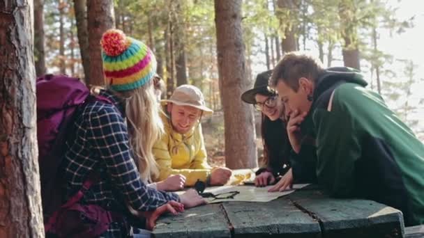 Grupo de jovens amigos consultando um mapa juntos — Vídeo de Stock