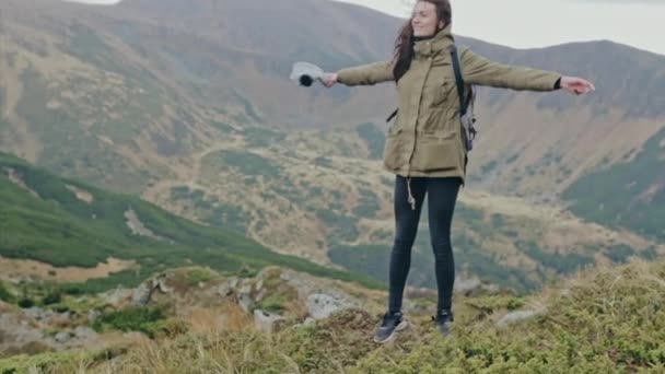 Joven mochilero de pie en una cumbre de montaña — Vídeo de stock