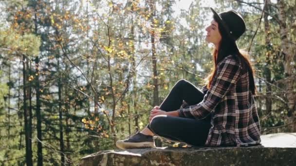 Femme rêveuse sur le rocher dans les bois — Video