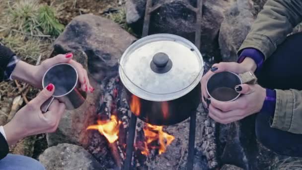 Cultivar mujeres tomando té cerca de la fogata — Vídeo de stock