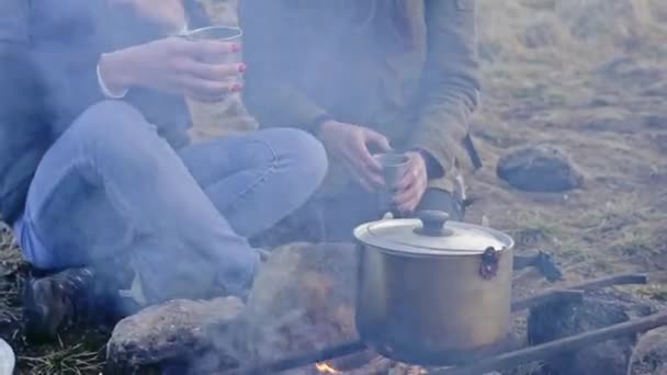 Дві молоді дівчата сидять біля вогню — стокове відео