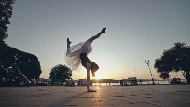 Mladá dívka v růžové baletní sukně je pěší vzhůru nohama. — Stock video