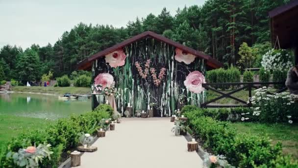 Rustikale Hochzeitsfotozone. Handgefertigte Hochzeitsdekoration umfasst Fotokabinen, Holzfässer und -boxen, Laternen, Koffer und weiße Blumen sowie eine alte Schreibmaschine, die auf Baumstumpf steht.. — Stockvideo