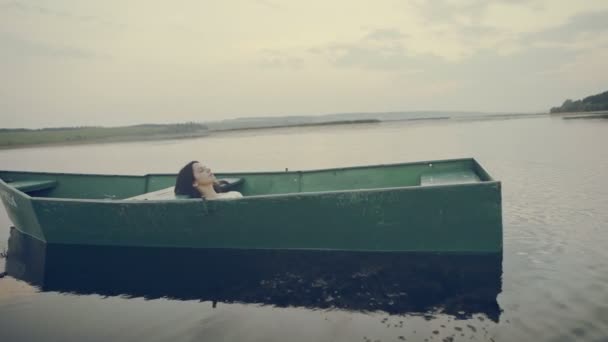 Typ grünes Boot, das von der Kamera abfährt. wie das Boot ein junges Mädchen ist. — Stockvideo