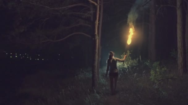 Une jeune fille court avec la torche à la lisière de la forêt. Mouvement lent . — Video