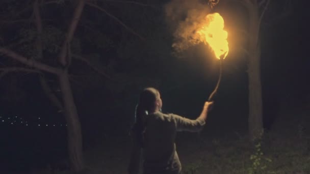 Portret van een jonge mystic vrouw in het donkere bos een toorts. Vrouw met de fakkel over donkere nacht achtergrond. Slow motion — Stockvideo