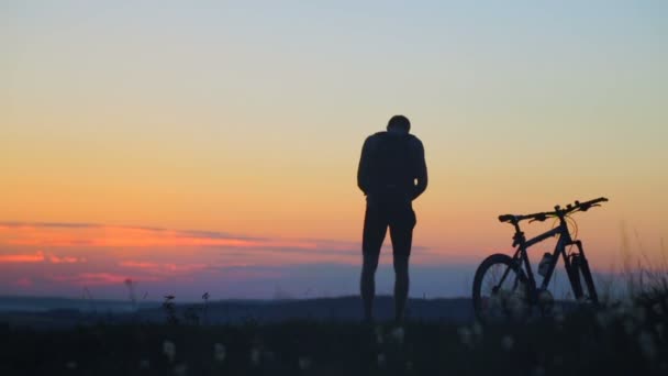 Saute sur la montagne du cœur. Silhouette cycliste heureux, a surmonté de nombreux obstacles pour atteindre le sommet . — Video