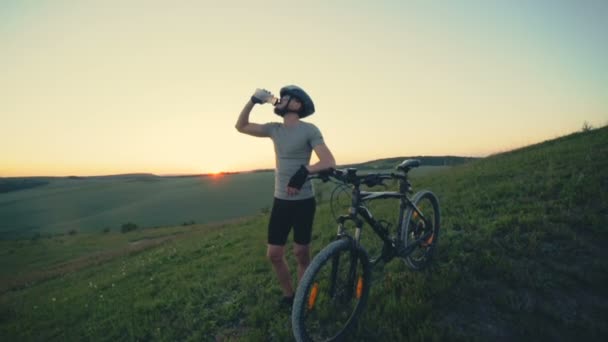 Велосипедист пьет воду из спортивной бутылки — стоковое видео