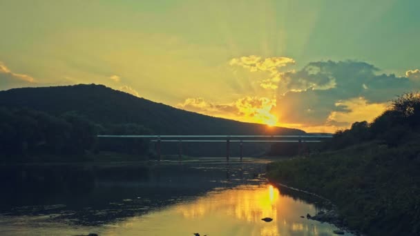 A csővezeték a folyón, a háttérben egy gyönyörű naplemente. — Stock videók