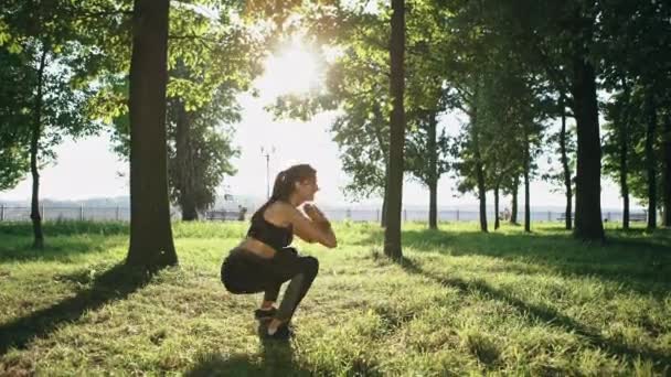 Schöne kaukasische Mädchen Sport treiben Kniebeuge Training im Park — Stockvideo