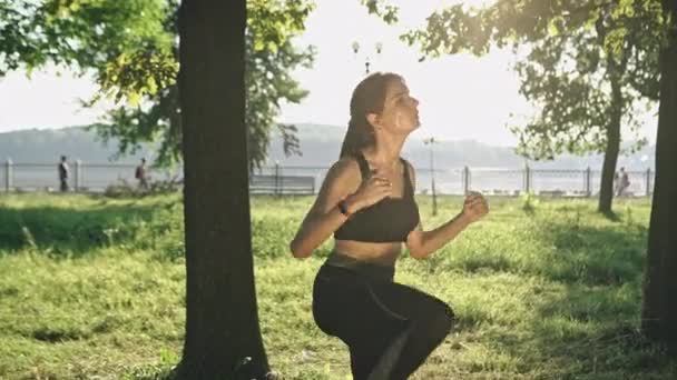 Hermosa mujer en forma ejercicios de fitness al aire libre. Entra a practicar deportes en el bosque natural y la hierba verde — Vídeos de Stock