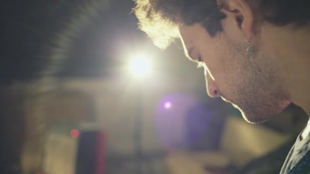 Лицо современного рок-музыканта во время репетиции в подвале с ярким светом в камере — стоковое видео