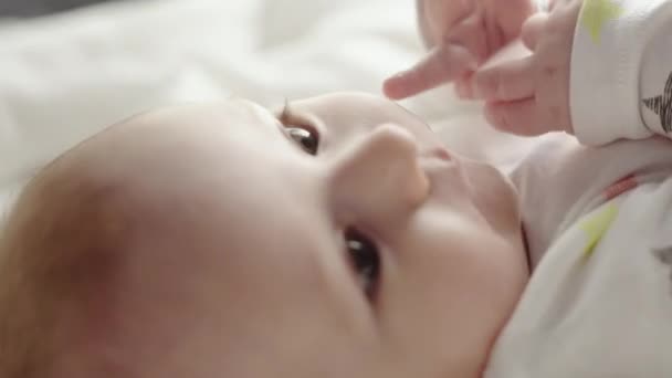 Pequeño bebé en manta blanca con buena cara de cerca . — Vídeos de Stock