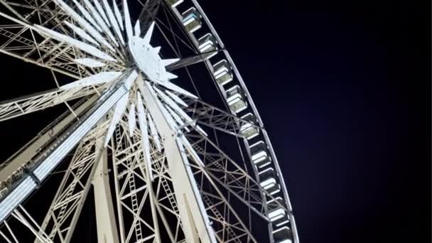 Blick nach oben auf ein beleuchtetes, rotierendes Riesenrad — Stockvideo