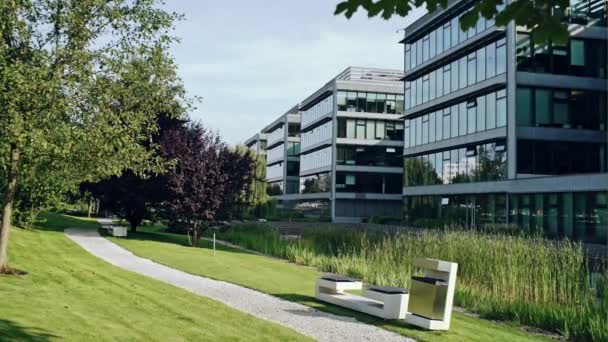 Edifício de escritórios moderno no parque da cidade. Vista de um bairro de negócios em verão — Vídeo de Stock