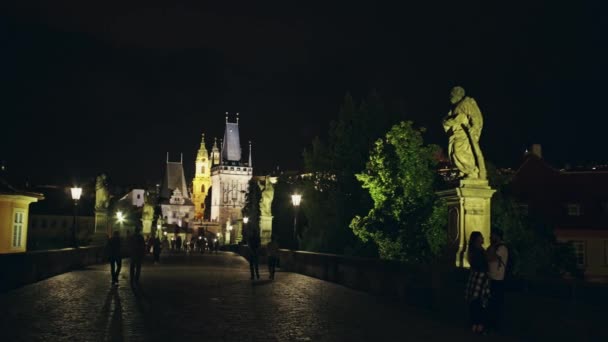 Two lovers of tourists kissing at night on the Charles Bridge in Prague, the Czech Republic — Stock Video