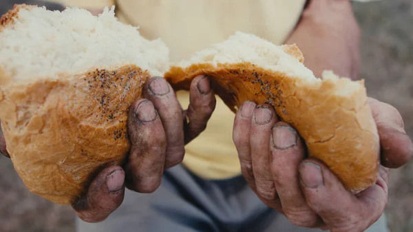 A loaf of bread in an old mans hands — Stock Photo, Image