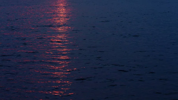 Puesta de sol reflejándose en la superficie del agua del lago — Foto de Stock