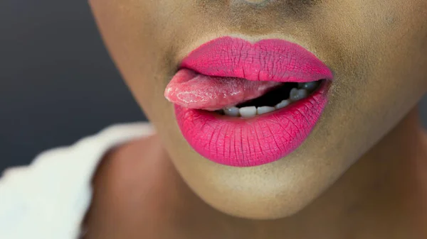 African woman licking sprinkles off lips — Stock Photo, Image