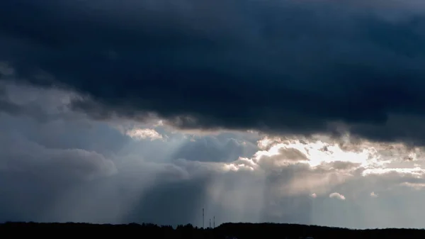 Ein Sonnenstrahl bricht durch dunkle Wolken. — Stockfoto