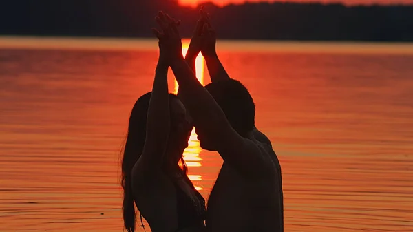 Пара в воде на пляже целуются — стоковое фото