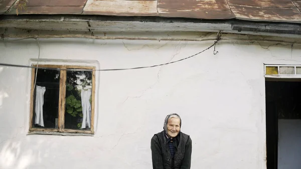 Mujer mayor linda de pie delante de casa — Foto de Stock