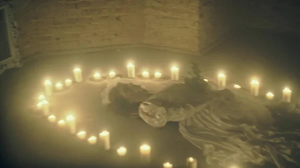 Scène de chagrin d'une mariée morte sur le sol comme un rituel avec des bougies — Photo