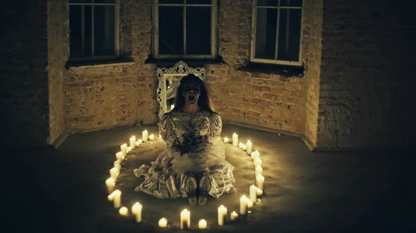 Corpse of bride on the floor around candles and flowers in her hands — Stockfoto