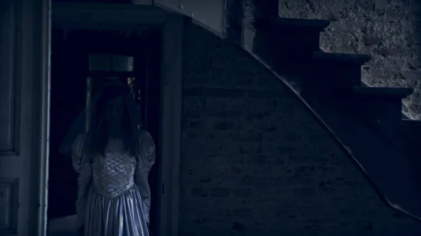Ghost κορίτσι σε λευκό φόρεμα που περιφέρεται στους διαδρόμους του ένα εγκαταλελειμμένο σπίτι — Φωτογραφία Αρχείου
