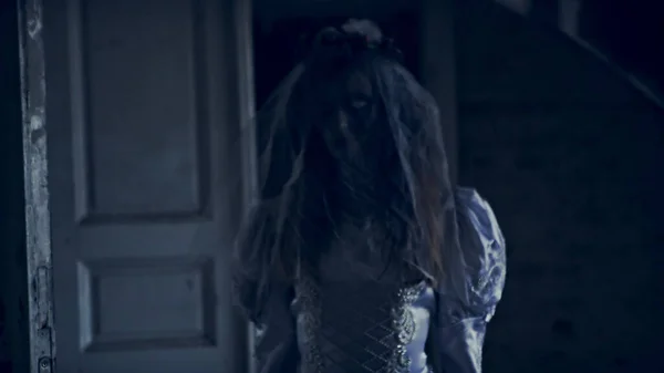 Menina fantasma em vestido branco vagando pelos corredores de uma casa abandonada — Fotografia de Stock