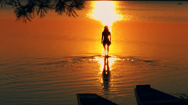 Mujer despreocupada en la puesta de sol en la playa. vitalidad de vacaciones concepto de vida saludable Imágenes de stock libres de derechos