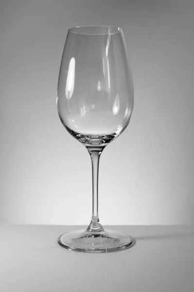 Photography of an empty wine glass, black and white picture on sober background, studio photo