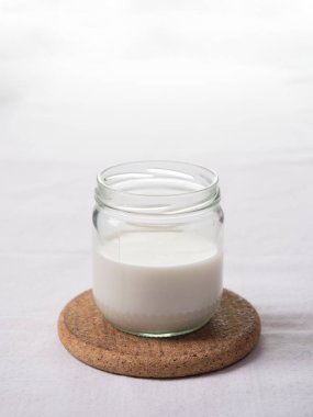 Işık arkaplanındaki yarım bardak sütü kapat.