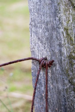Kırsal bölgedeki bir çitin üzerindeki paslı metalik tel.