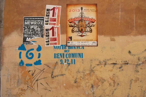 Pisa, Toskana 'da duvarda sokak posterleri ve grafiti var.