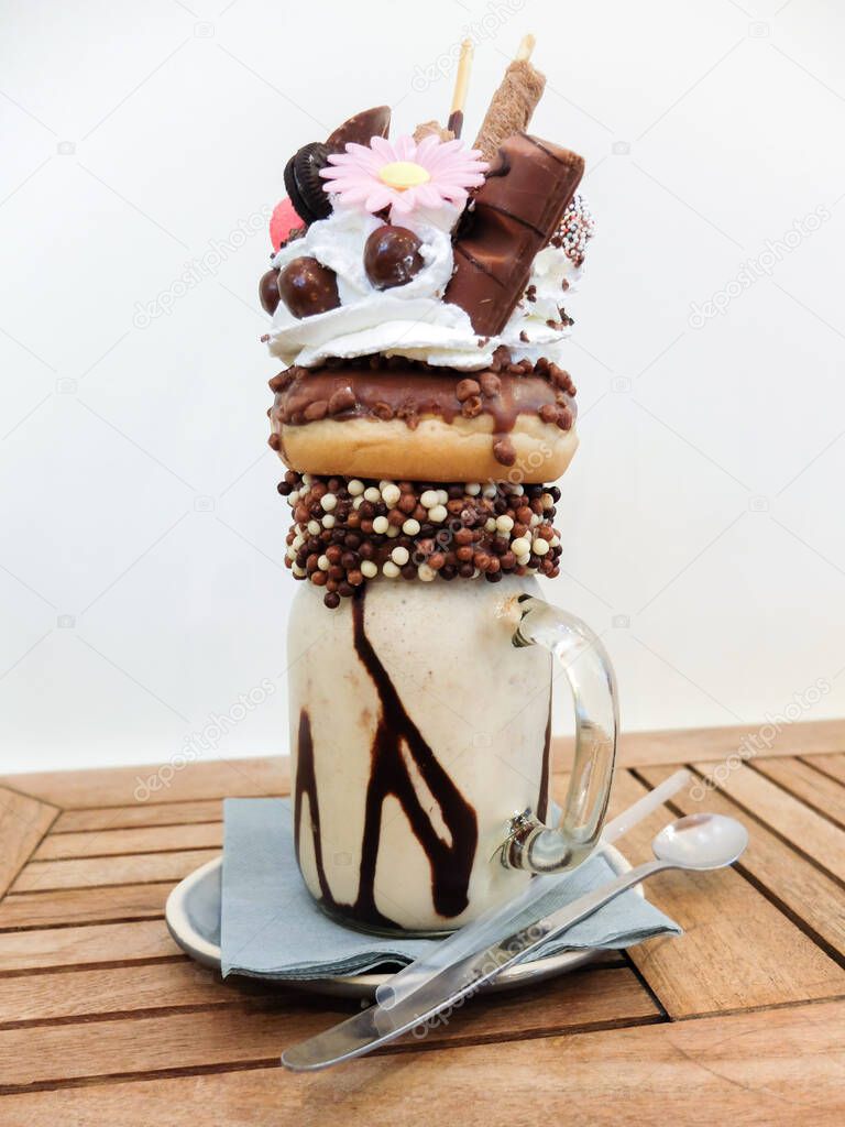 Freakshake, a kind of gourmet Milkshake with topping : donut, whipped cream, chocolate ball, wafer biscuits, candy, mikado, mini ice cream cake
