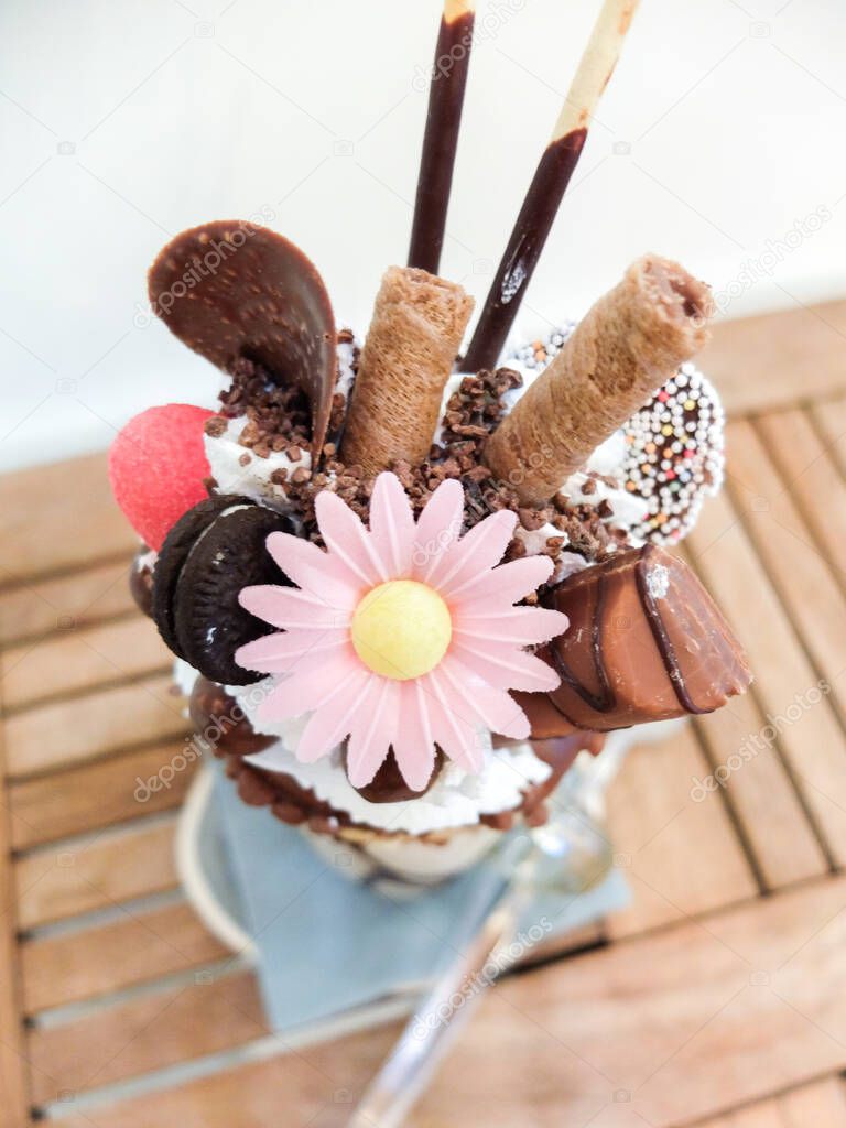 Freakshake, a kind of gourmet Milkshake with topping : donut, whipped cream, chocolate ball, wafer biscuits, candy, mikado, mini ice cream cake