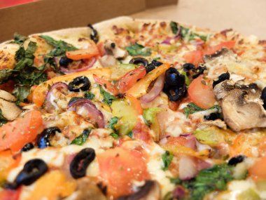 Kalın kenarlı, büyük, güzel bir sebzeli pizzaya yaklaş.