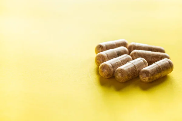 Vitamin pills on a yellow background