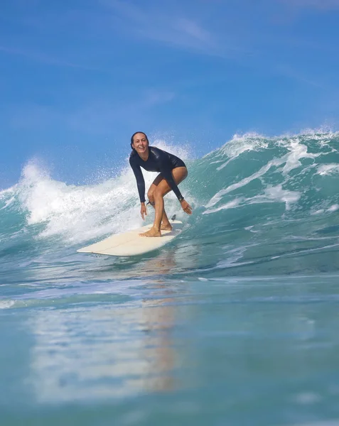 晴れた日に青い波の上に女性サーファー — ストック写真