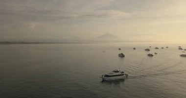 Arka planda Agung volkanı ve tekneleri görüyoruz.