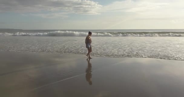 Vista aérea da mulher caminhando na praia — Vídeo de Stock