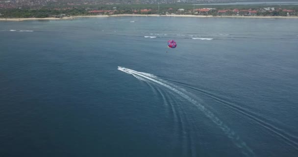 Vista aérea de persona parasailing y lancha a motor — Vídeo de stock