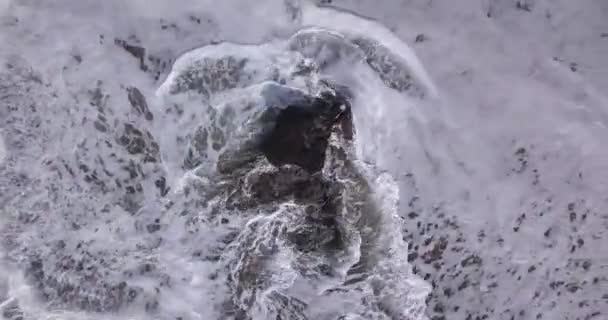 Luftaufnahme von Wellen, die über Felsen am Strand von Batu Bolong stürzen — Stockvideo