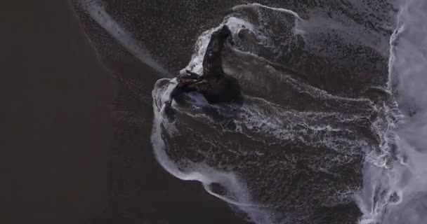 Luftaufnahme von Wellen, die über Felsen am Strand von Batu Bolong stürzen — Stockvideo
