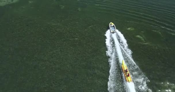 Вид с воздуха на катер и банановую лодку — стоковое видео