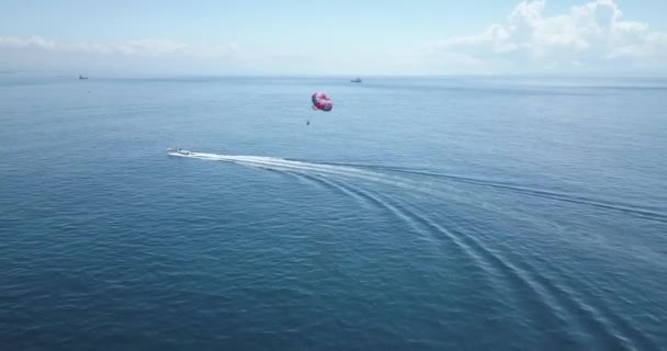 Luchtfoto van person parasailing en motorboot — Stockvideo