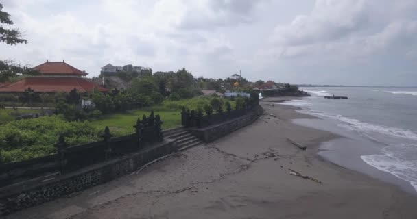 Letecký pohled na chrámovou stěnu na pláži Batu Bolong — Stock video