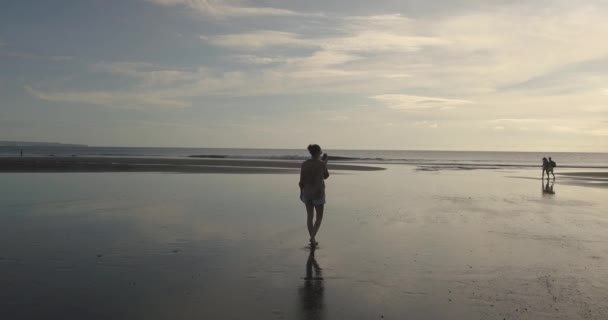 Vista aérea de una joven caminando por la playa — Vídeo de stock