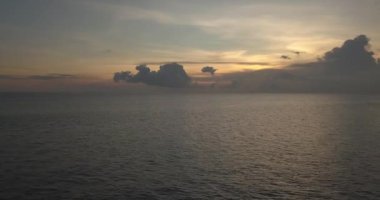 Gün batımında okyanusta sörfçülerin hava görüntüsü